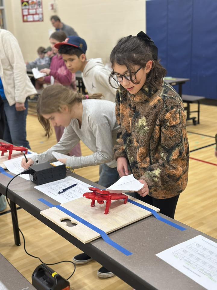 Students at Mid-Columbia Partnership test paper airplanes at a STEM workshop.